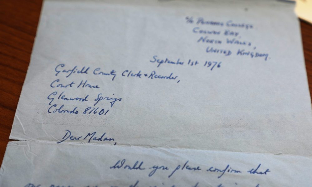 A handwritten letter to the Garfield County Clerk's Office requesting voter registration status from 1976. It was mailed from Colwyn Bay, North Wales, UK.