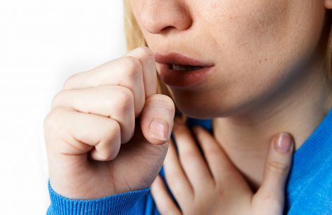 Close-up of a woman coughing.
