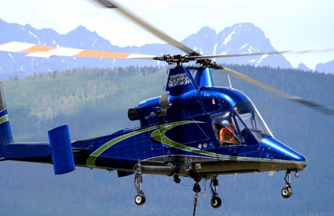 A blue helicopter is seen in the mountains.