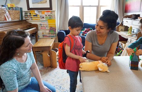 Childcare provider Stephanie Northrup looks on while parent Alexis Diaz and her son Keanu play with the new breastfeeding-friendly educational toys.