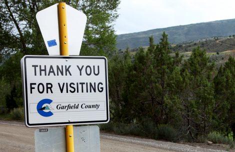 A thank you for visiting Garfield County sign on a remote county road.
