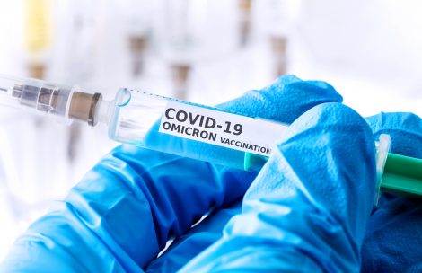 COVID-19 omicron variant vaccine vial in a doctor's hand.