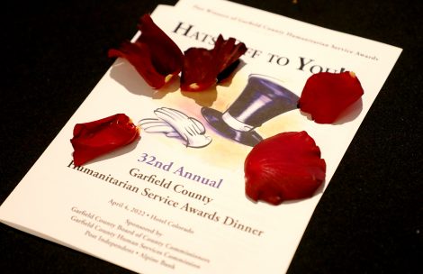 The program for the 2022 Garfield County Humanitarian Service awards gala. Red rose petals are scattered about.