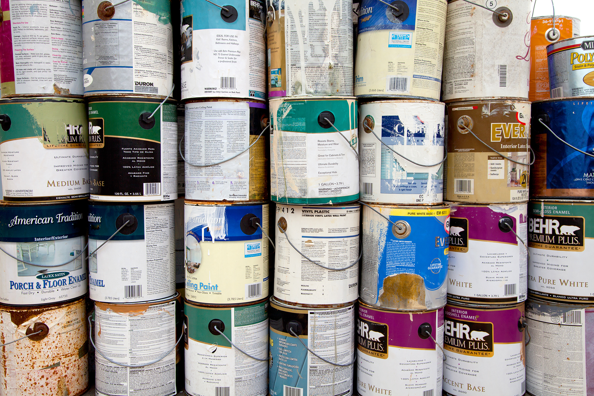 Latex paint cans stacked in a pile. The paint will be separated, processed for recycling.